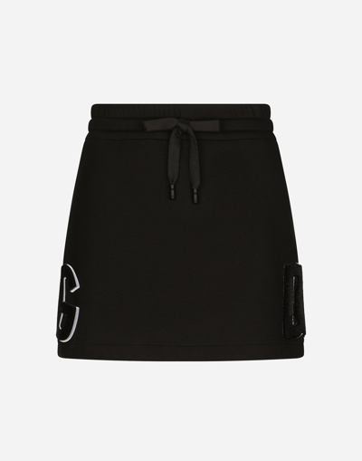 DOLCE & GABBANA JERSEY MINISKIRT WITH LOGO PATCH