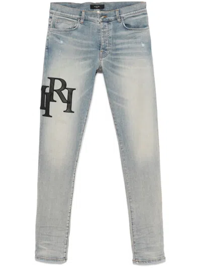 AMIRI STAGGERED LOGO SKINNY JEANS