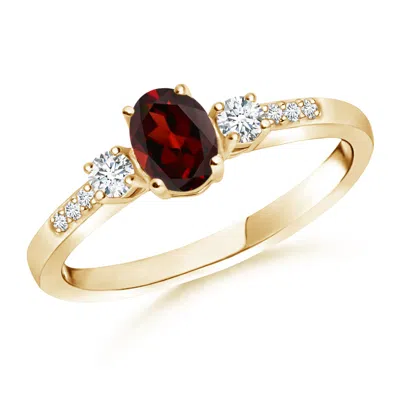 ANGARA CLASSIC OVAL GARNET AND ROUND DIAMOND THREE STONE RING