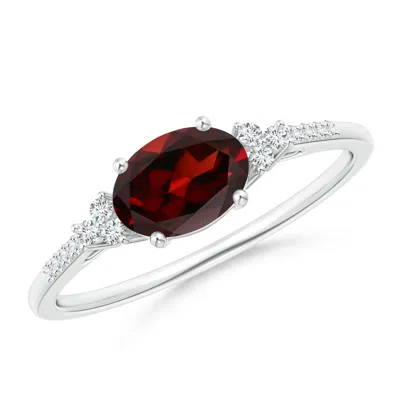 ANGARA HORIZONTALLY SET OVAL GARNET SOLITAIRE RING WITH TRIO DIAMOND ACCENTS