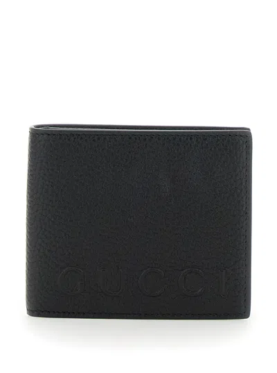GUCCI GUCCI MEN BLACK BI-FOLD WALLET WITH EMBOSSED LOGO LETTERING ON THE FRONT IN GRAINED LEATHER MAN