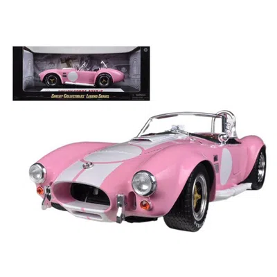 SHELBY COLLECTIBLES 1965 SHELBY COBRA 427 S & C PINK WITH PRINTED CARROLL SHELBY SIGNATURE ON THE TRUNK 1-18 DIECAST CAR